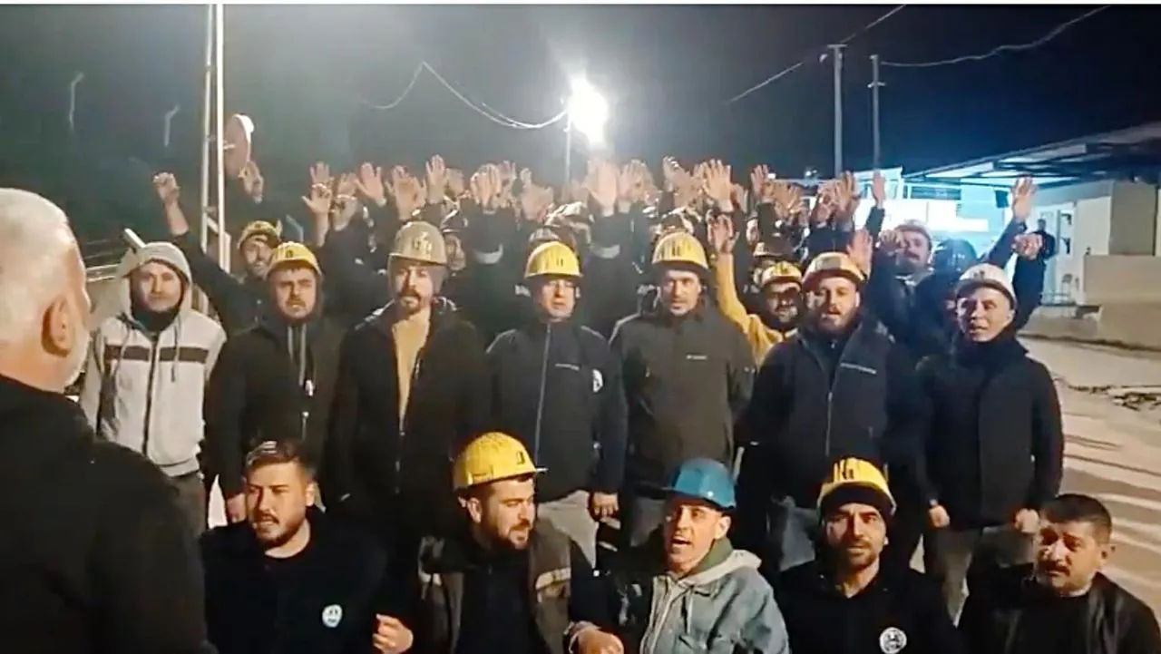 Polyak Mining coal miners in hard hats raise their hands in a vote during the wildcat strike at night, Kınık, İzmir